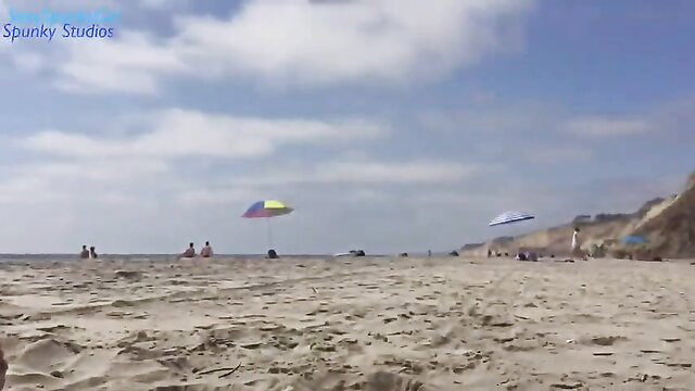 Crowded beach scene with umbrellas and people at sunny shore