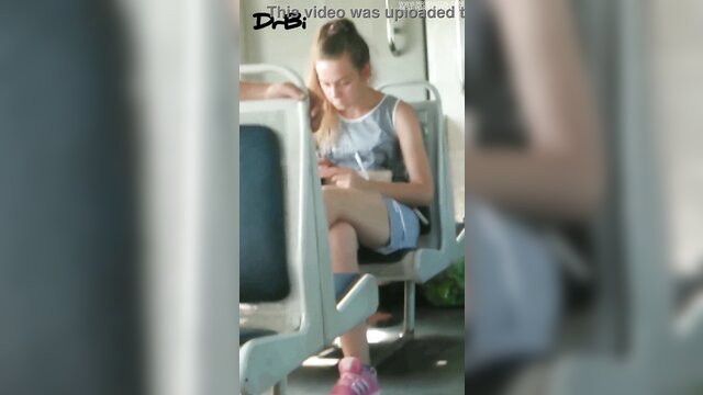 Teen girl in short shorts and pink sneakers sits on train seat
