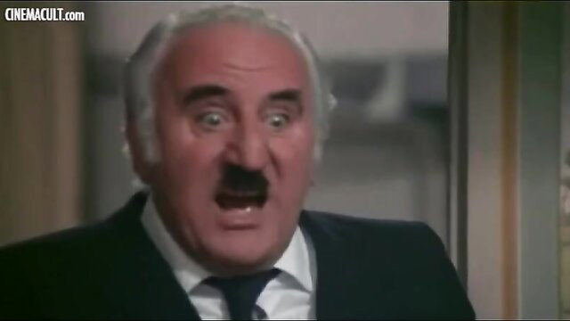 Bald Italian actor with Hitler mustache yelling in suit from classic comedy