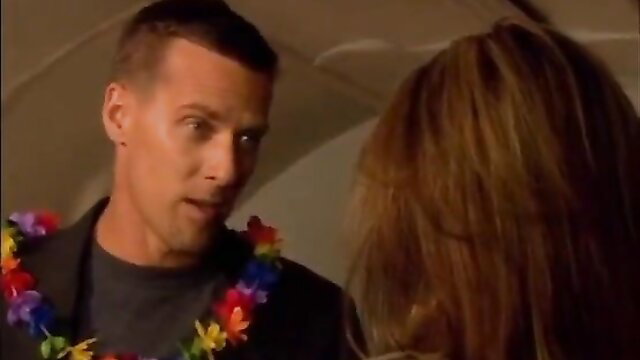 Hot guy in Hawaiian lei talks to brunette on airplane in sex on plane scene
