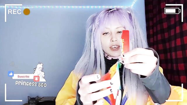 Purple-haired Asian cosplay girl holds credit card in yellow outfit, amateur selfie