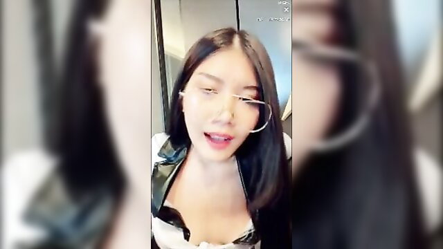 Asian beauty in shiny latex top with big hoop earrings smirking seductively