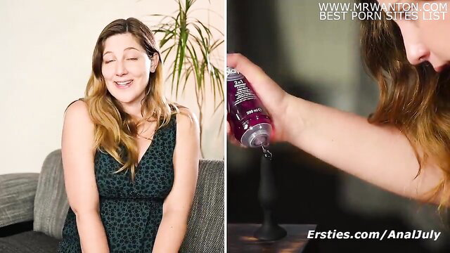 Kate smiling in dress, pouring lube on dildo for #AnalJuly solo play