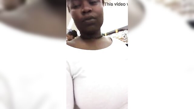 Closeup of black woman's face and huge cleavage in tight white top