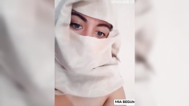 Arab Maghreb veiled beauty in white hijab, blue eyes, bare shoulders tease