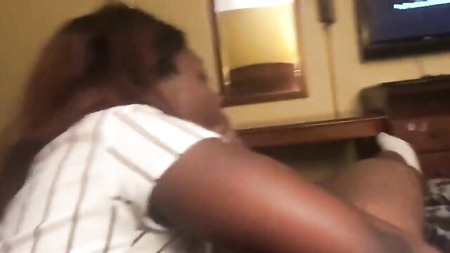 Ebony woman in striped top on bed in amateur bedroom scene