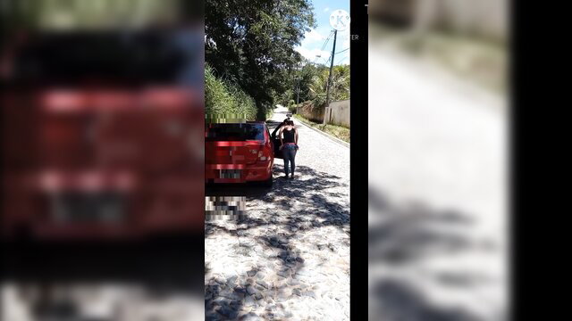 Exhibitionist Brazilian wife in tight jeans bends over red car outdoors