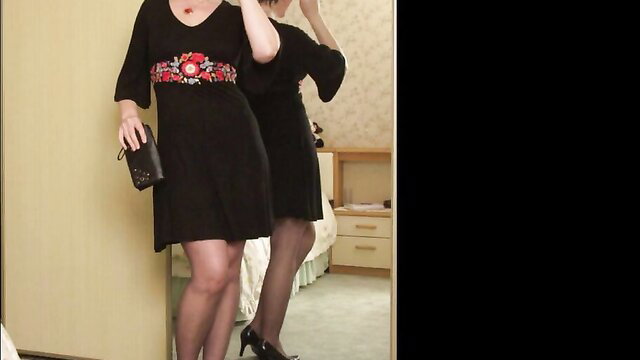 Mature Miss Jones in black floral dress, stockings, heels mirror pose