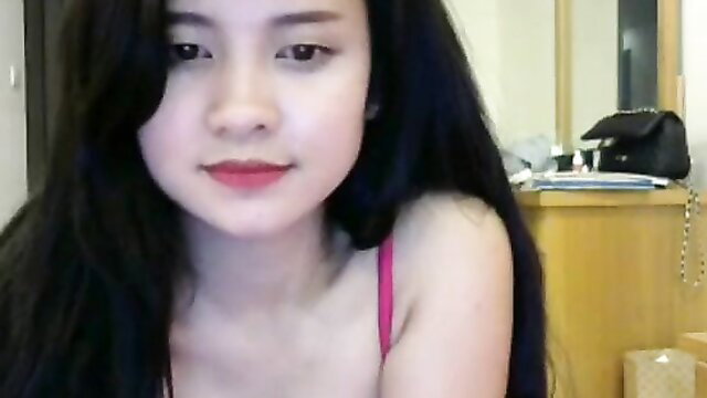 Cute Asian girl in pink tank top, smiling closeup selfie