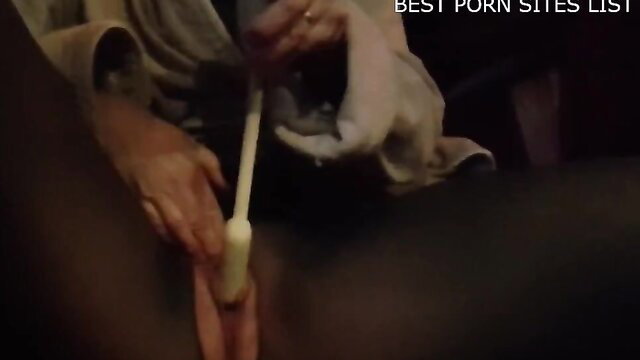 Woman masturbating with white vibrator in van, closeup insertion