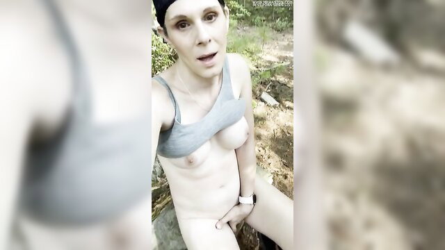 Pale redhead trans woman fingers pussy topless in forest