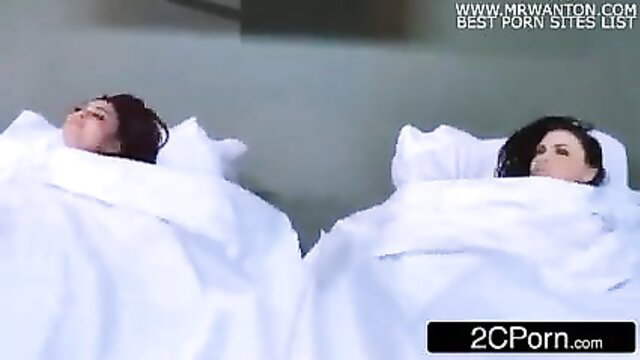 Two busty brunettes side by side in white sheets after massage fuck