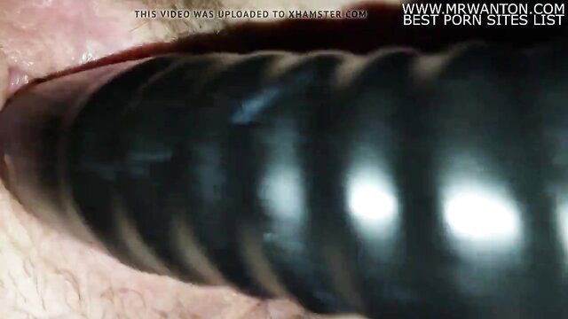 Extreme closeup of gaping anus with black ribbed dildo insertion