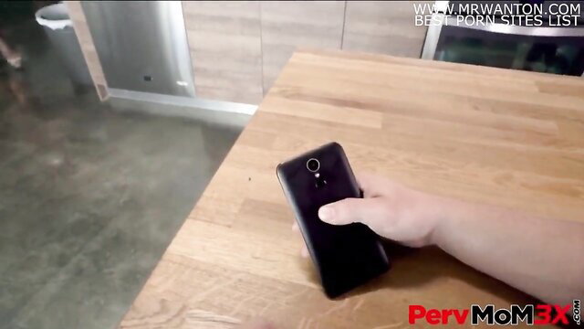 Helena Price holds phone with hand on black phone on table