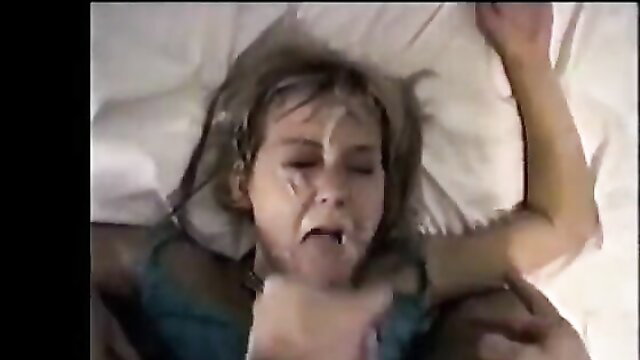 Blonde teen girl lying back with face covered in cum, begging for facial