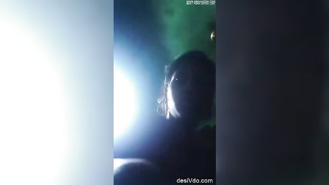 Blurry closeup of unknown Asian woman in dim green-lit room POV