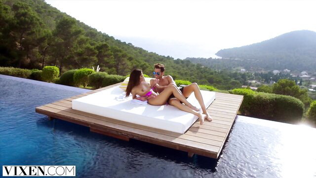 Hot exhibitionist couple cuddling topless on pool float in VIXEN
