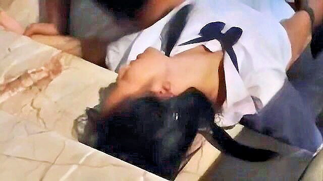 Asian woman in white bow shirt lying head back on table, neck exposed, amateur JAV style