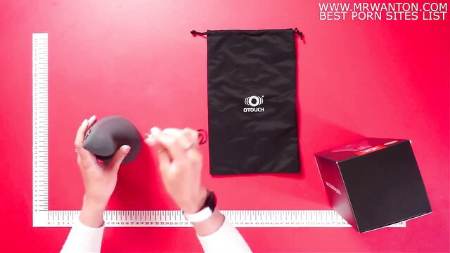 Woman unboxing OTouch black masturbator toy on red background