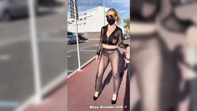 Blonde in sheer black lace top and metallic pants poses sexy outdoors