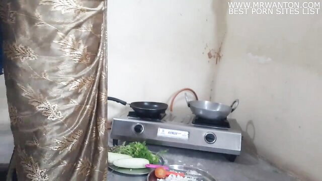 Chubby maid in gold saree by stove in kitchen morning scene