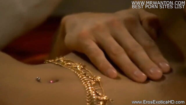 Exotic beauty with gold belly chain in steamy oral sex embrace