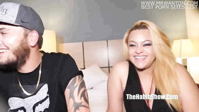 Smiling white couple in bed, guy with beard hat tattoos, blonde smiling big tits