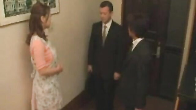 Busty Asian wife in apron chats with suited husband brother