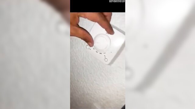 Hand adjusting white knob on wall near blurred skin in homemade BBW BBC tease