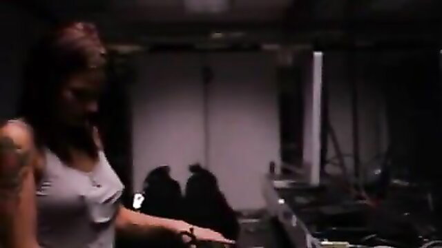 Tattooed redhead in tank top holds gun in dim room, La journaliste 2012