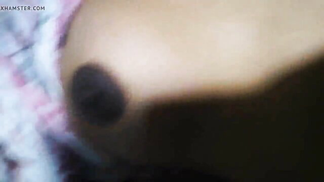 Closeup of Asian woman's large brown nipple and areola in pink lingerie