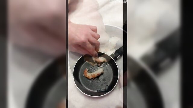 Amateur Italian hand peels fried shrimp in pan closeup