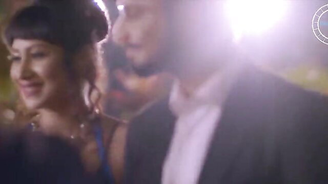 Blurry closeup of smiling brunette woman with man in suit at night event
