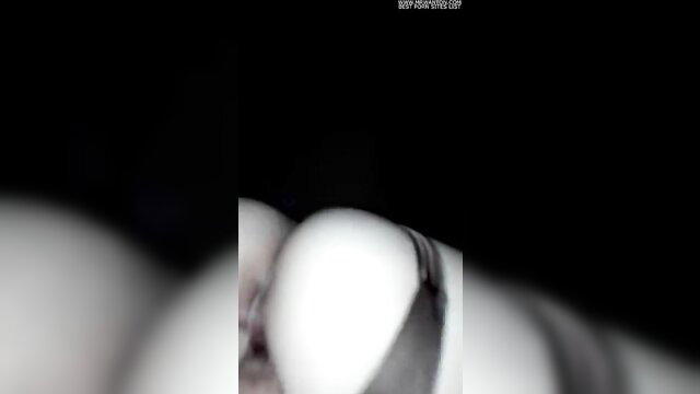 Blurry closeup of pale woman's big tits and bound nipples in dim light