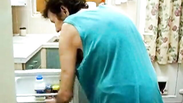 Old skinny granny bending over kitchen sink in tank top