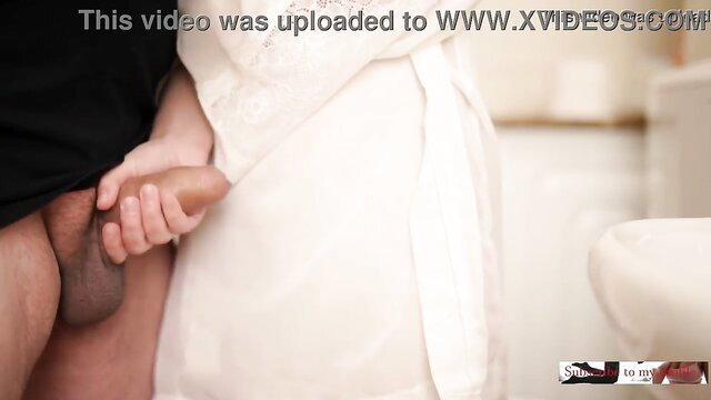 Woman in white dress gives helping handjob to man's big cock in bathroom