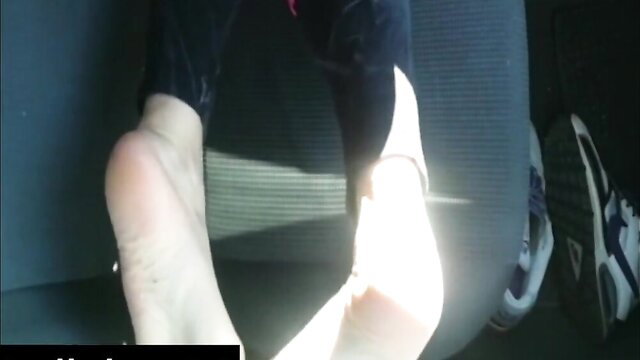 Closeup of woman's bare soles with anklet, feet near man's sneakers in voyeur scene