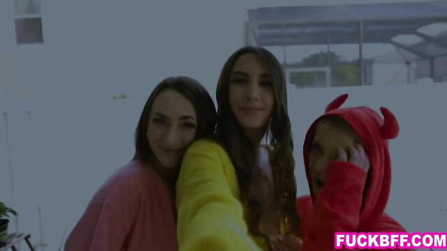 Cute teen BFFs in colorful outfits with devil hood selfie smile