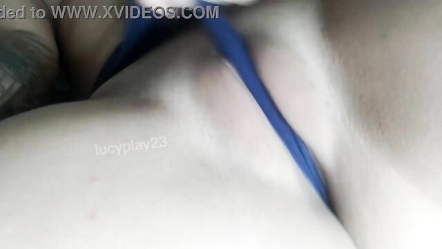 Naughty young woman teases pussy with blue thong, playful masturbation closeup