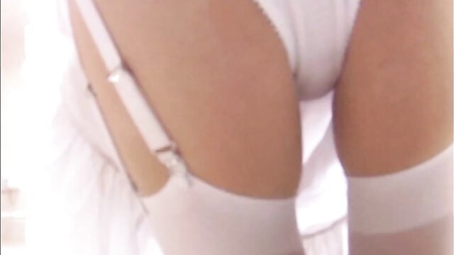 Closeup of woman in white lingerie, garter stockings and dress
