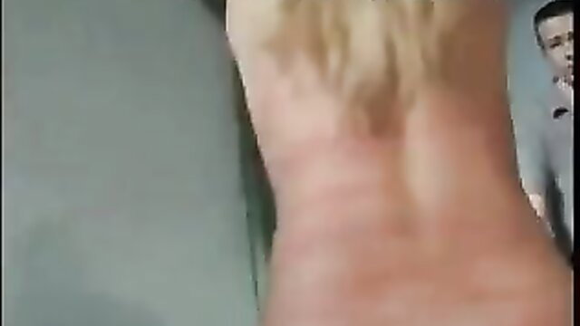 Blonde woman nude back view whipped red, man watches in amateur BDSM