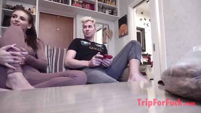 Hot brunette in tight leggings cuddles gamer guy while barefoot on couch