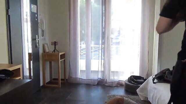 Mistress Andrea Parker with man in hotel room, strap-on prep