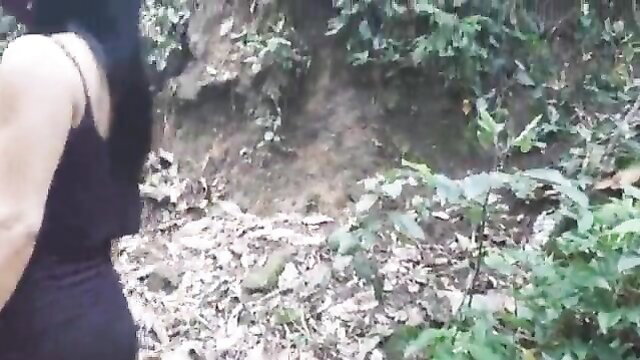 Brazilian brunette in black tank top hikes in jungle woods
