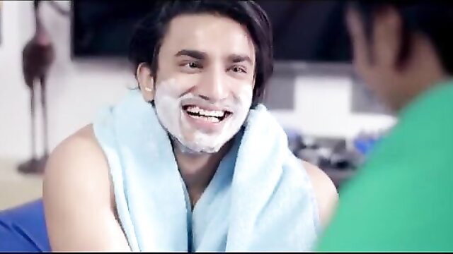 Handsome Indian man with shaving cream smiling shirtless in towel