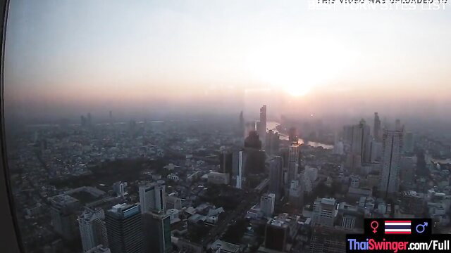Bangkok skyline sunset view from high-rise window, amateur teen couple day out