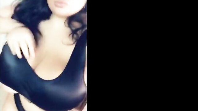 Curvy brunette bombshell in tight black dress squeezing huge cleavage