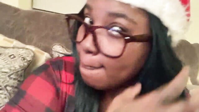 Black amateur babe in Santa hat and glasses teases lips closeup