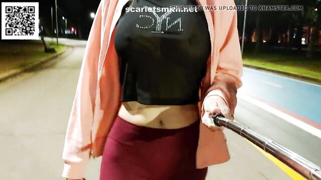 Hotwife in pink cardigan and black sheer top exposing midriff in park at night