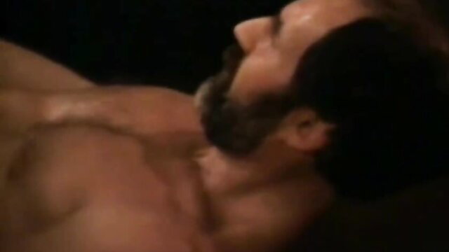 Muscular bearded man lying shirtless in bed, Sweet Dreams Suzan adult scene